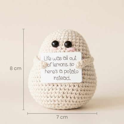 Crocheted potato with a humorous message and measurements on a beige background