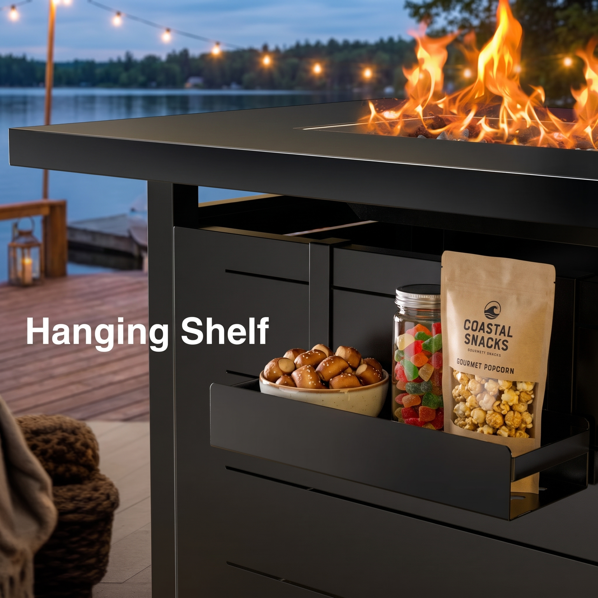 Black outdoor fire pit table with hanging shelf displaying snacks, set against a lakeside evening scene.