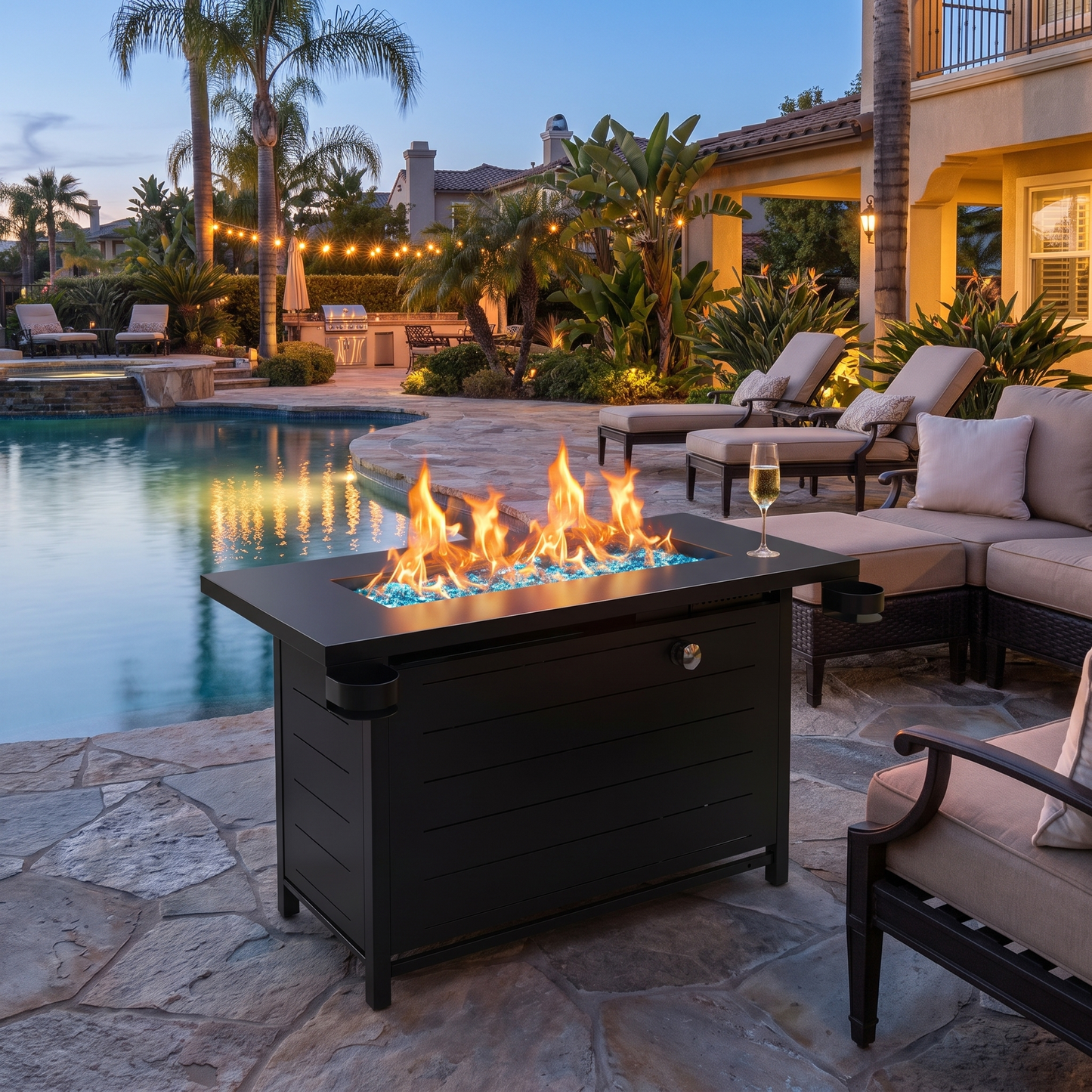 Outdoor patio with fire pit table by a pool at dusk