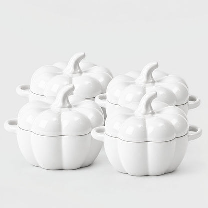 Set of four glossy white ceramic pumpkin bowls with white stems and loop handles arranged in two rows on a plain light backdrop