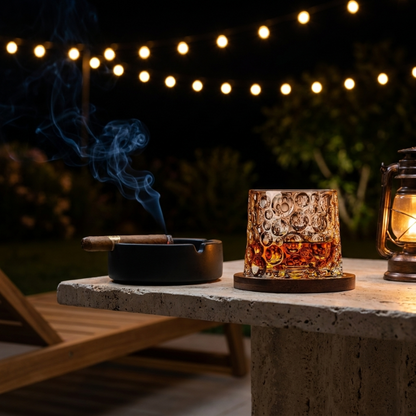 Rotating whiskey glass with wood coaster on outdoor table at night