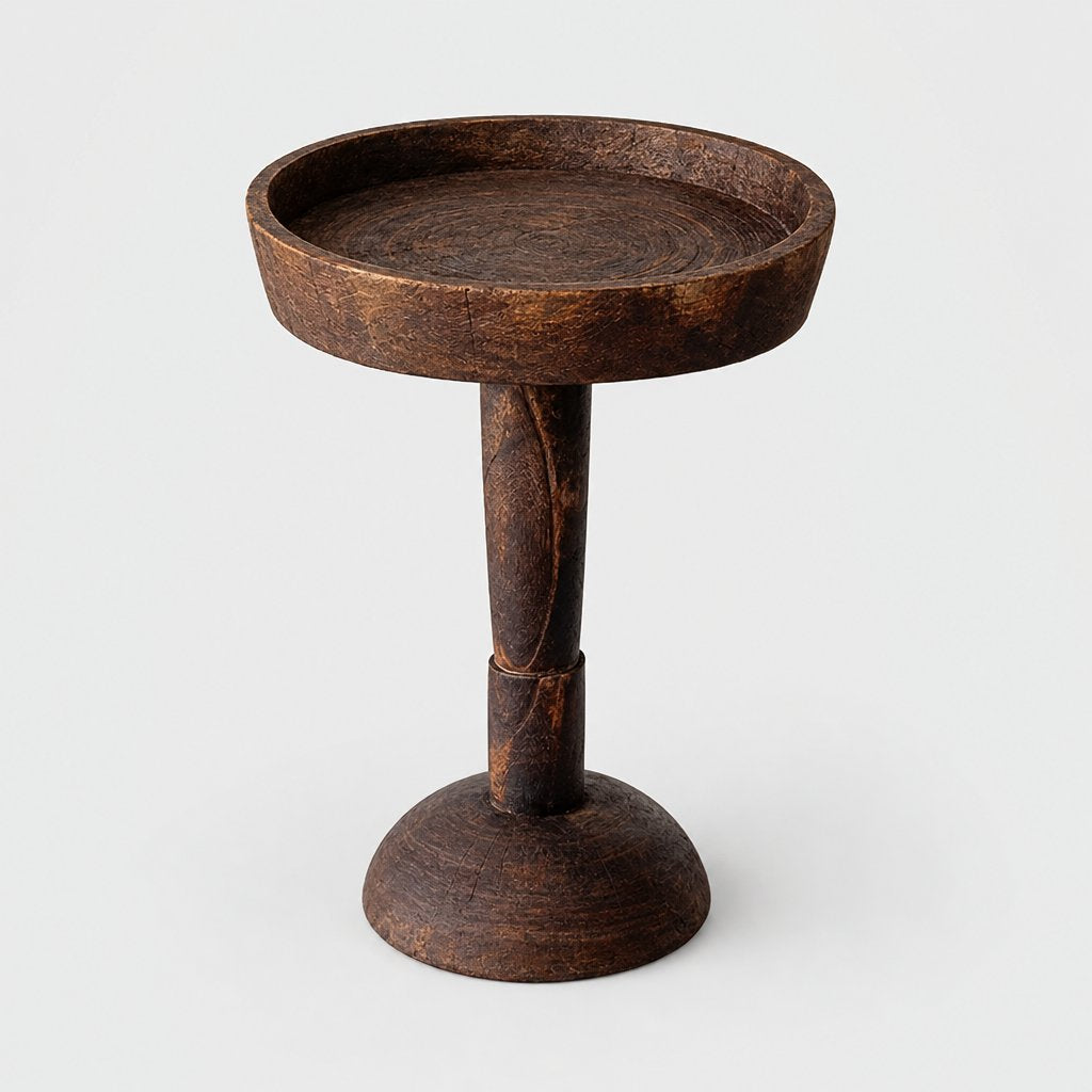 Medium dark wood round pedestal side table with a shallow raised rim and a flared round base on a light grey background