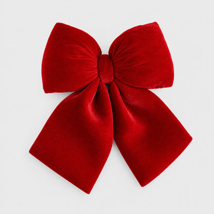 Large red velvet bow on a plain light background