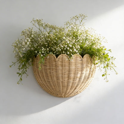 Wicker wall basket with greenery against a light gray background