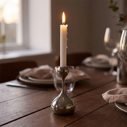 Candle in a silver holder on a wooden table with a blurred background