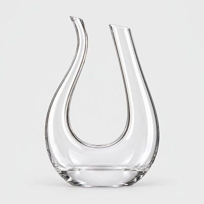 Clear U shaped glass wine decanter with two upright arms and a wide base on a light grey background