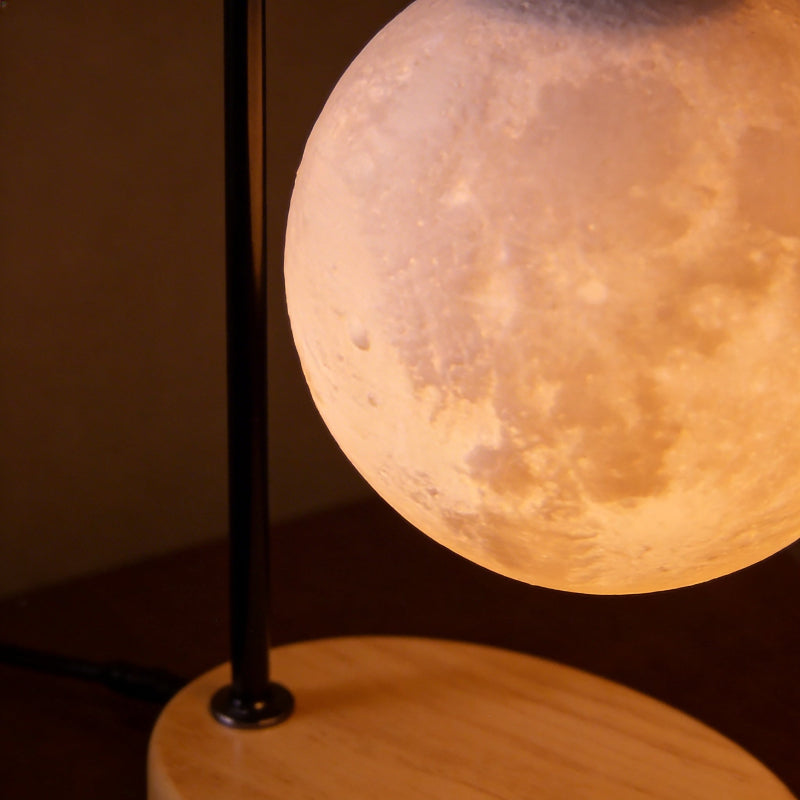 Moon-shaped lamp with wooden base on a dark background