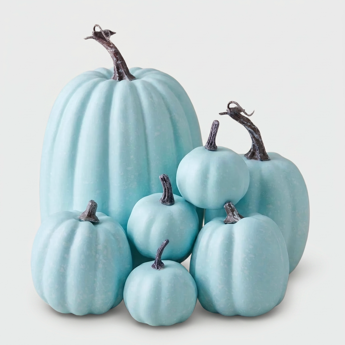 Set of seven pastel blue decorative pumpkins on a clean off-white background