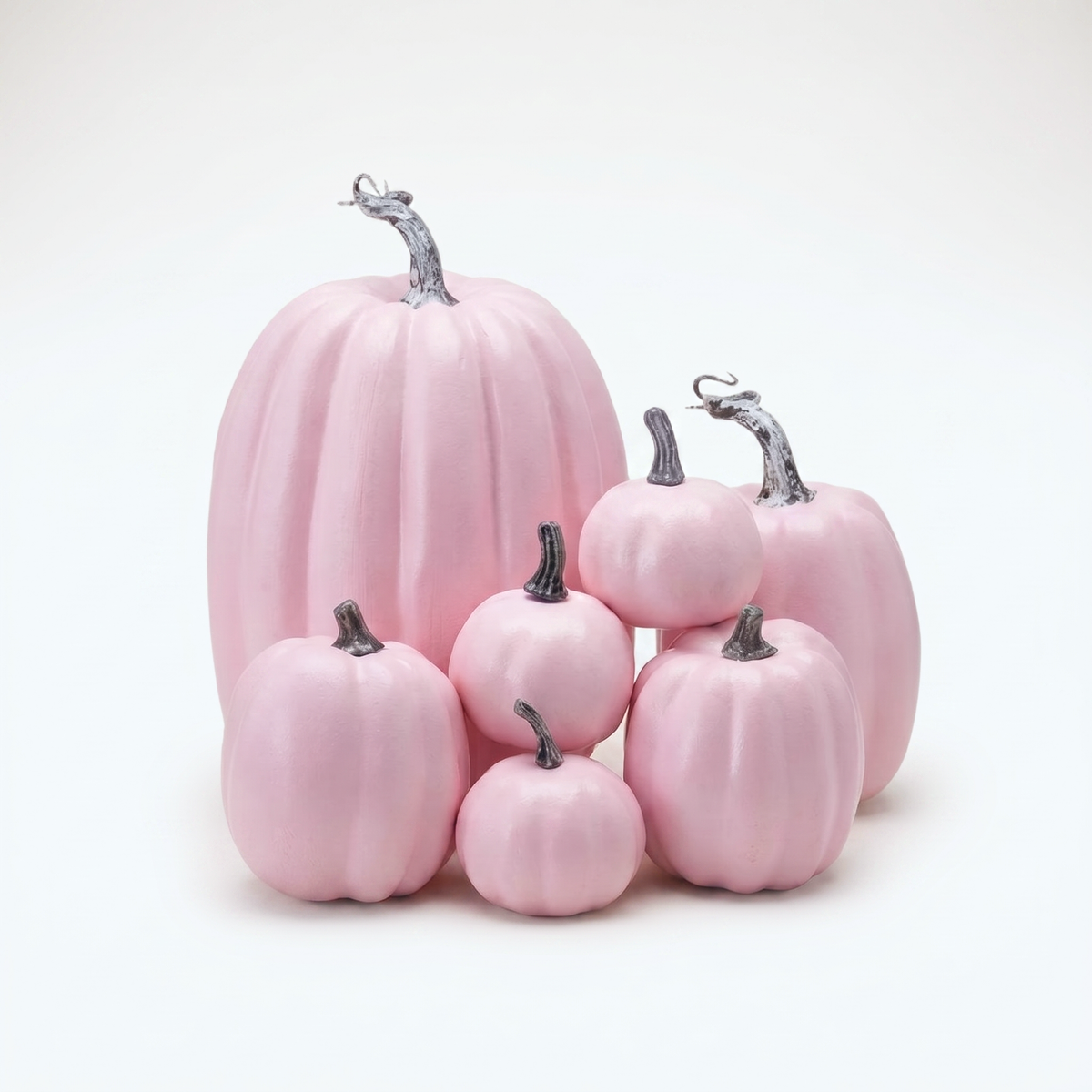Set of seven pastel pink decorative pumpkins on a clean off-white background