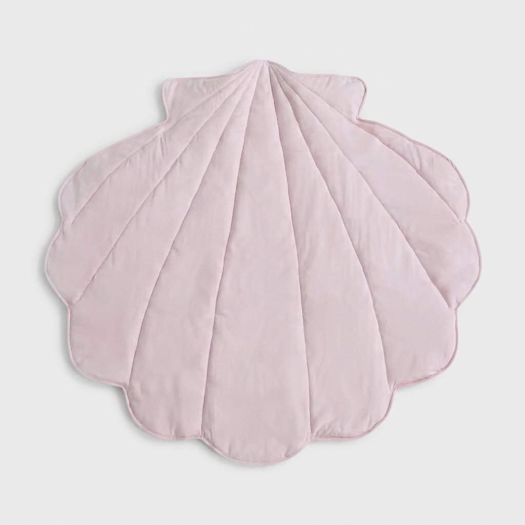 A light pink, scalloped shell-shaped quilted blanket or play mat, photographed flat against a neutral light gray background.