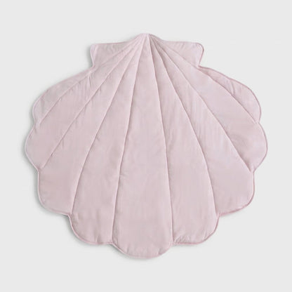 A light pink, scalloped shell-shaped quilted blanket or play mat, photographed flat against a neutral light gray background.