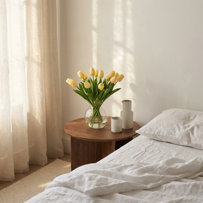 Faux silicone tulips in bedside vase in softly lit bedroom