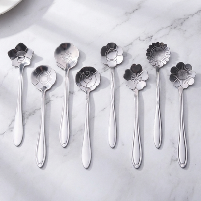 Set of silver spoons with floral ends on a marble surface