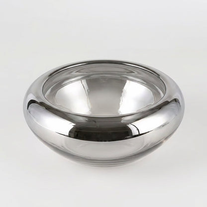 Empty mirrored silver glass bowl centered on a plain white studio background