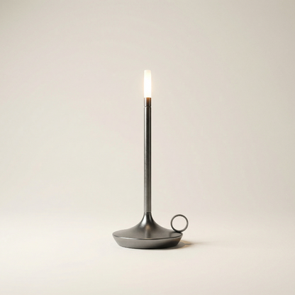 Black candle holder with a lit candle on a beige background
