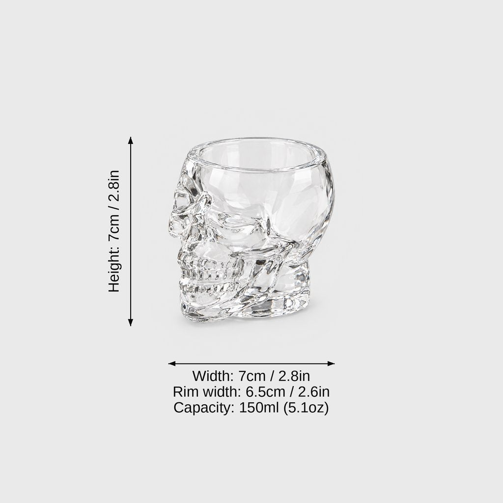 Medium clear glass skull glass on a light gray background with dimension labels: height 7 cm or 2.8 in, width 7 cm or 2.8 in, rim width 6.5 cm or 2.6 in, capacity 150 ml or 5.1 oz