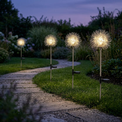 Four dandelion-shaped solar lights lighting a curved stone garden path edged with lawn at dusk
