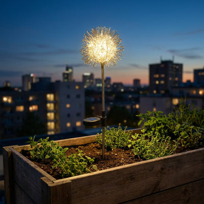 Single dandelion-shaped solar light glowing in a raised wooden planter of herbs with a city skyline behind at dusk