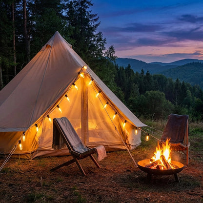 Lit tent with chairs and a fire pit in a forest at dusk