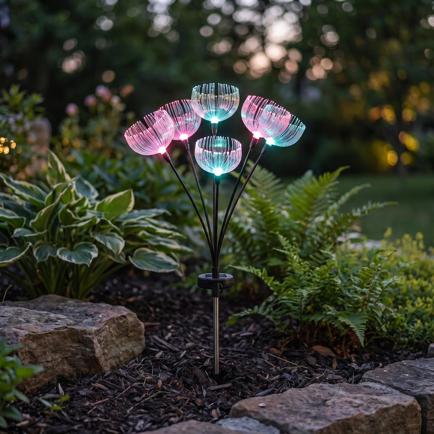 Single color-changing jellyfish-style fiber-optic solar garden light stake with seven light heads glowing in a garden bed