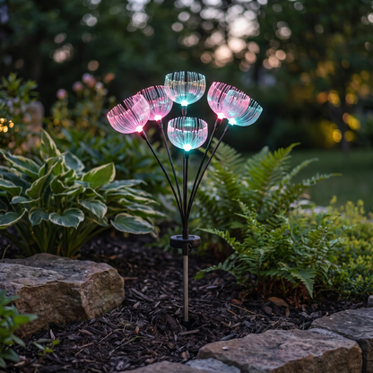 Single color-changing jellyfish-style fiber-optic solar garden light stake with seven light heads glowing in a garden bed