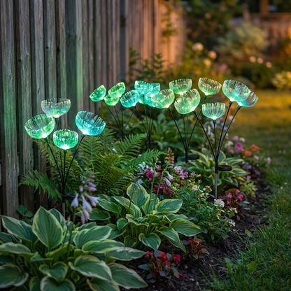 Color-changing solar jellyfish garden lights glowing green and teal in a flower bed at dusk