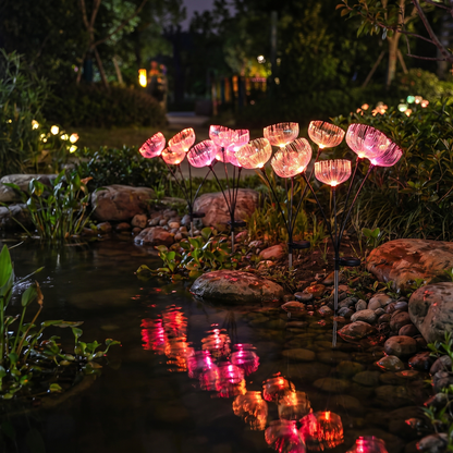 Color-changing jellyfish-style fiber-optic solar garden lights glowing pink beside a garden pond at night