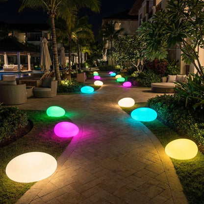 Colorful illuminated outdoor lights on a pathway in a tropical setting