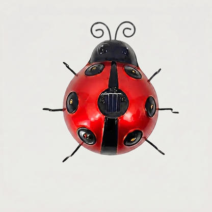 Red solar metal ladybug garden light on white background