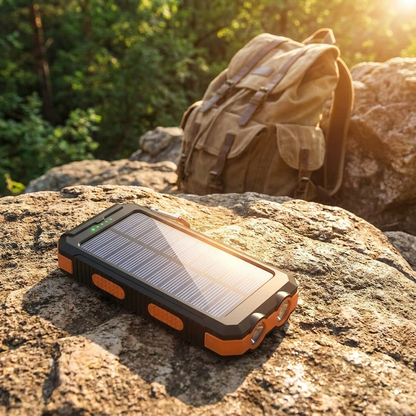 Solar powered portable charger resting on a rock outdoors charging in sunlight