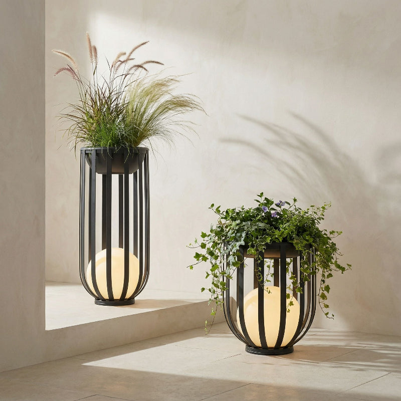 Two modern outdoor lamps with planters on a neutral background