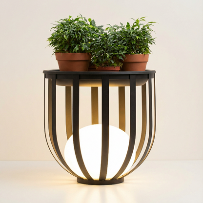 Decorative table with a spherical light fixture and three potted plants on a plain background