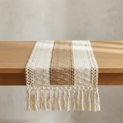 Textured table runner with fringes on a wooden surface