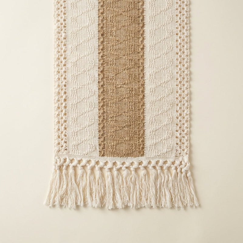 Textured woven wall hanging with striped pattern and tassels on a beige background
