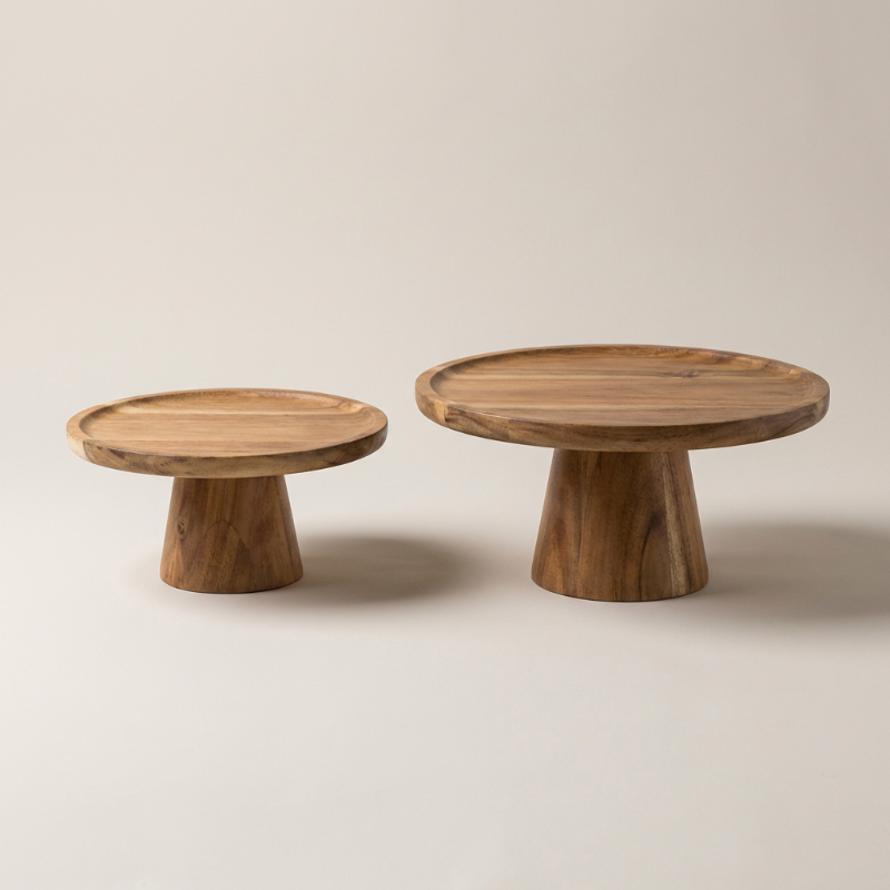 Two wooden pedestal tables on a plain background
