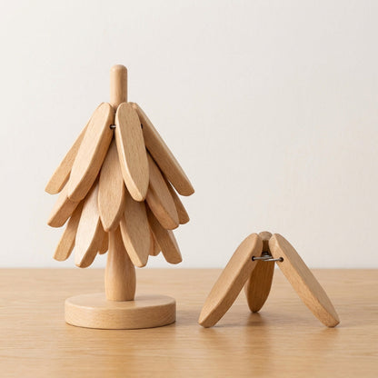 Wooden tree-shaped object on a wooden surface with a plain background