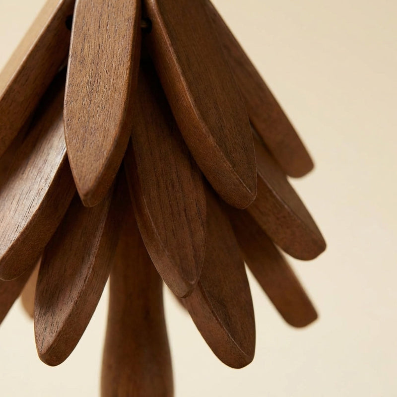 Wooden sculpture resembling a tree with layered branches on a beige background