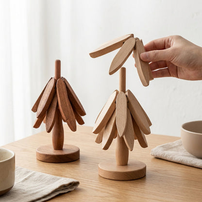 Wooden tree-shaped objects on a wooden table with a hand interacting with one of them.