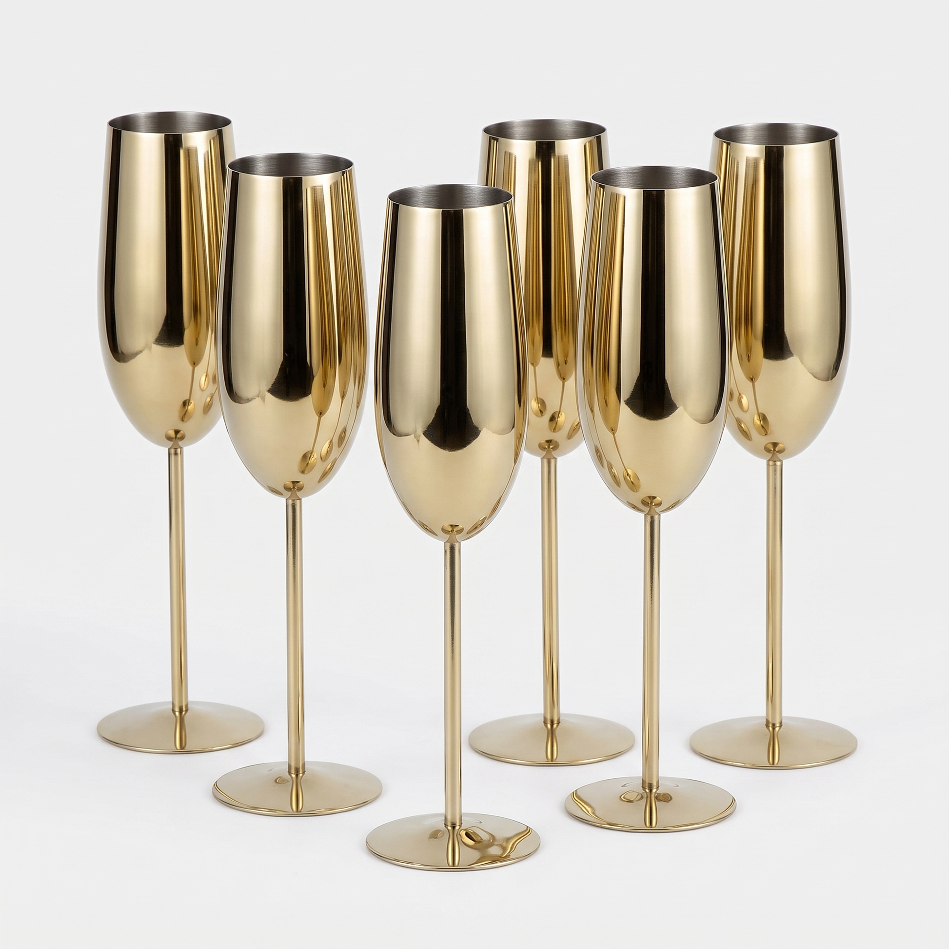 Set of six gold stainless steel stemmed champagne flutes with a mirror-polished finish on a clean off-white background