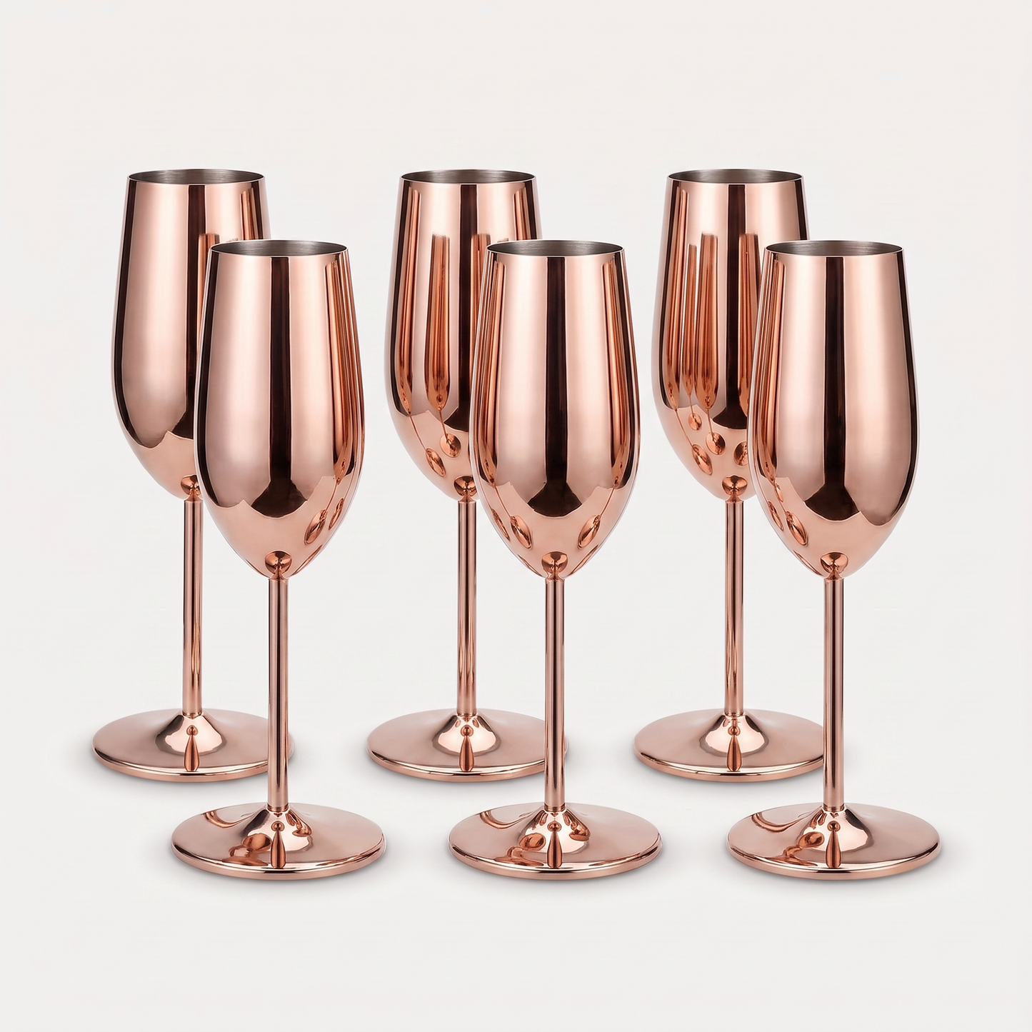 Set of six rose gold stainless steel stemmed champagne flutes with a mirror-polished finish on a clean off-white background