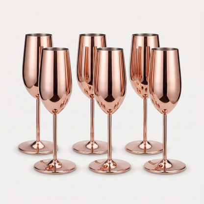 Set of six rose gold stainless steel stemmed champagne flutes with a mirror-polished finish on a clean off-white background