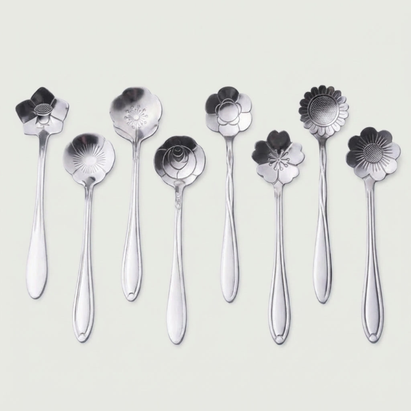 Set of silver floral spoons on a light gray background