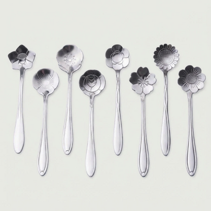 Set of silver floral spoons on a light gray background