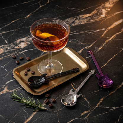 Stainless steel guitar spoon beside cocktail glass in moody setting