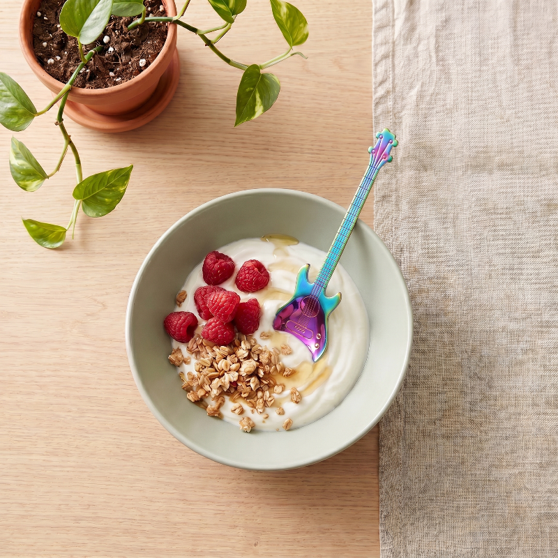 Stainless steel guitar spoon beside yogurt bowl with fruit