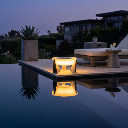Stainless steel solar lamp glowing beside a pool at night