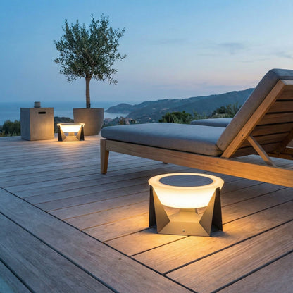 Outdoor setting with a wooden lounge chair and table lamp on a wooden deck.