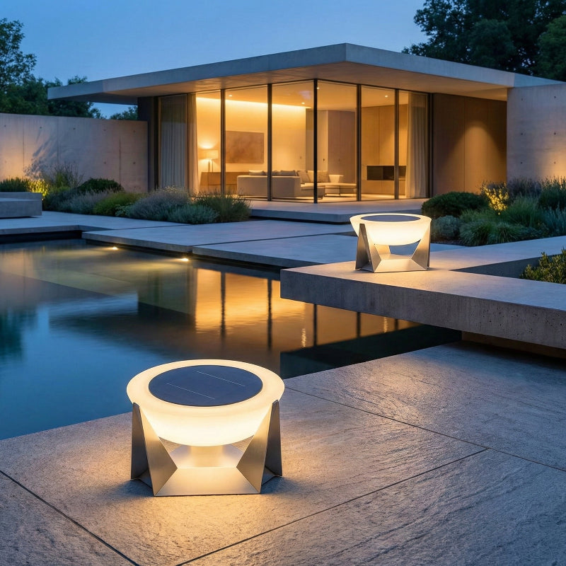 Modern outdoor setting with illuminated furniture near a pool at dusk.