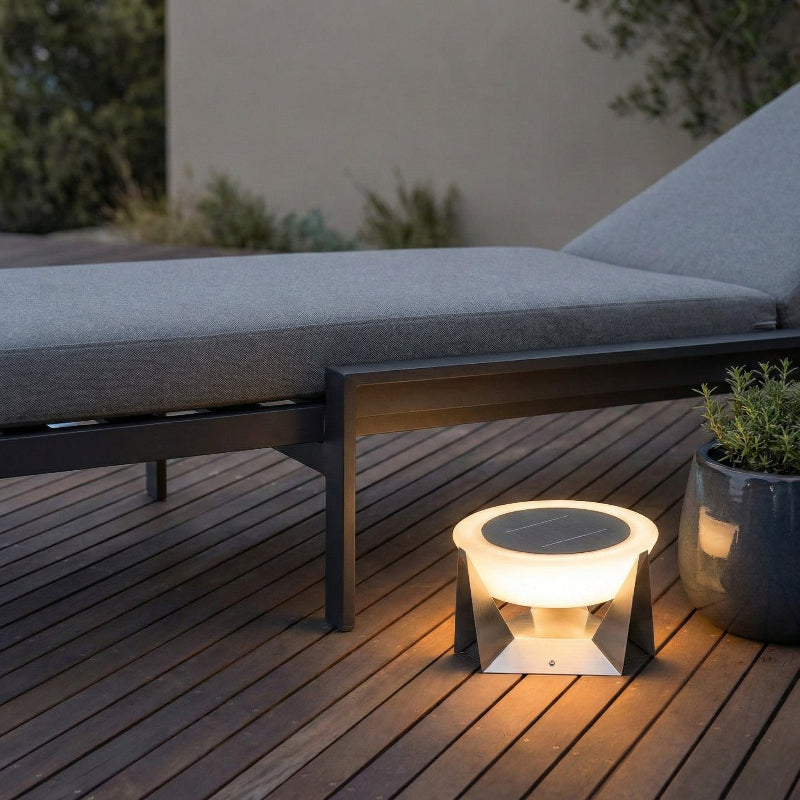 Solar-powered outdoor light on a wooden deck with a lounge chair in the background
