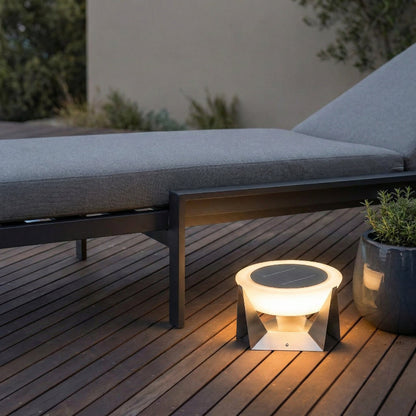 Solar-powered outdoor light on a wooden deck with a lounge chair in the background